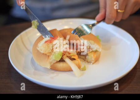 Close-up burger coupe blured flou ou soft focus, holding burger coupé en deux moitiés blured flou ou soft focus, fromage burger, jeune femme fine burge Banque D'Images