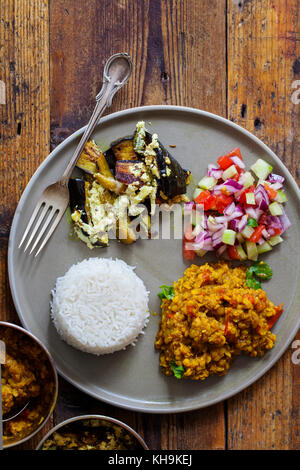 Repas indien avec le masoor dal - curry de lentilles, dahi baingan, riz et salade Banque D'Images