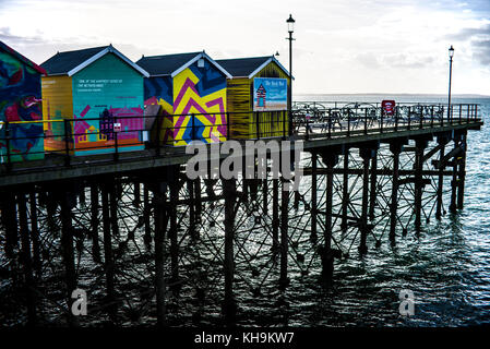 Cabanes aux couleurs vives à l'extrémité de Southend Pier avec structure en treillis de jambe de fer regardant vers le soleil et l'estuaire de la Tamise, Essex, Royaume-Uni Banque D'Images