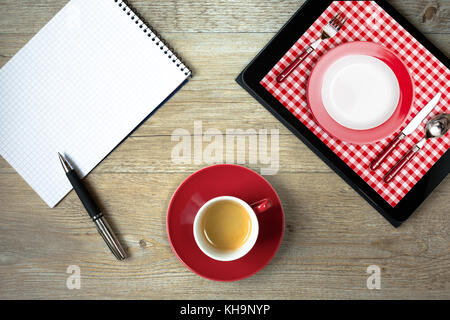 Ordinateur tablette avec photo de table de dîner et lave en rouge et blanc vue de dessus Banque D'Images