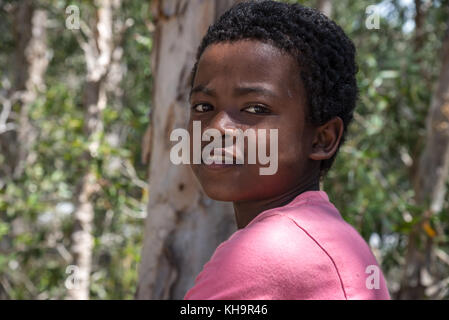 Un jeune garçon malgache en rose t-short. Madagascar, Afrique. Banque D'Images