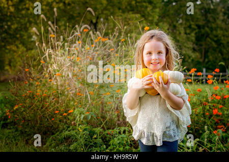 Young Girl holding pumpkins Banque D'Images