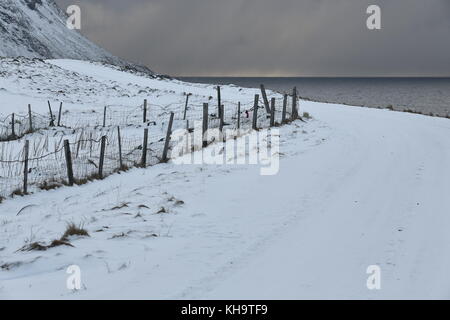 Ciel au-dessus de la tempête menaçante couvertes de neige et de galets, la plage de Boulders à eggum village de pêcheurs noircir les eaux de l'norskehavet-Norvège à la mer Banque D'Images