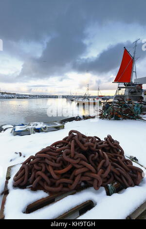 Bouquet de chaînes rouillées sur palette en bois de 5 ancres sur le grappin tined couvertes de neige pier-bateaux de pêche amarrés dans le port de eggum prêt à downdoad Banque D'Images