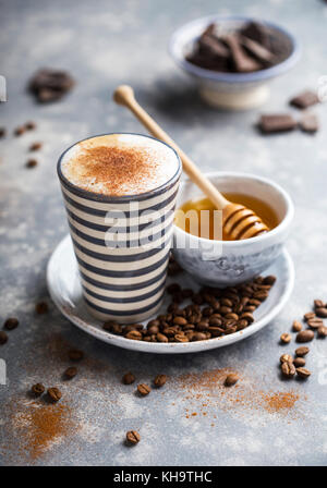 Grande tasse de café avec lait et miel fouetté Banque D'Images