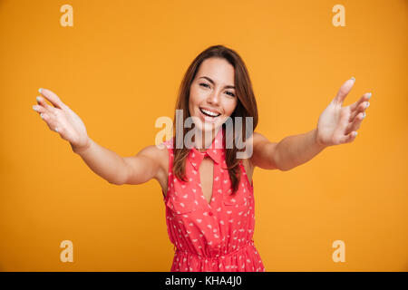 Close-up portrait of attractive young woman stretching her arms, veut vous embrasser, isolé sur fond jaune Banque D'Images