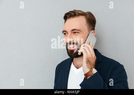 Beau Portrait d'homme barbu en parlant de vêtements officielle sur smartphone gris plus isolés Banque D'Images