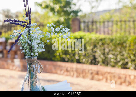 Bouteille avec bouquet sur fond de jardin. Vintage décoration pour mariages Banque D'Images