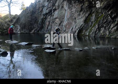 Deux femmes ont diminué les marcheurs à rydal cave balade sur les pas japonais au-dessus de l'eau dans le rydal parc national de lake District, Cumbria, Royaume-Uni. Banque D'Images