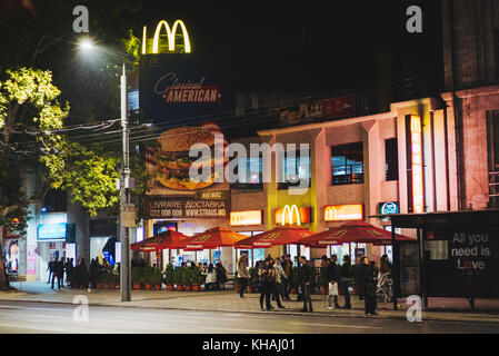 L'un des rares restaurants Mcdonald's de Chisinau, Moldova, annonce un 'big mac' américain classique alors que les clients s'asseoir en face de manger fast food Banque D'Images