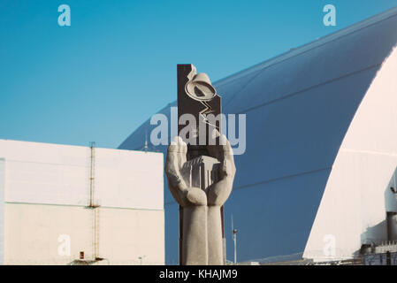 Une statue commémorative se trouve à l'extérieur du dôme de la gare centrale de Tchernobyl en Ukraine (derrière) Banque D'Images