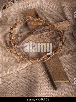 Croix de bois, couronne d'épines et de clous sur une toile de jute Banque D'Images