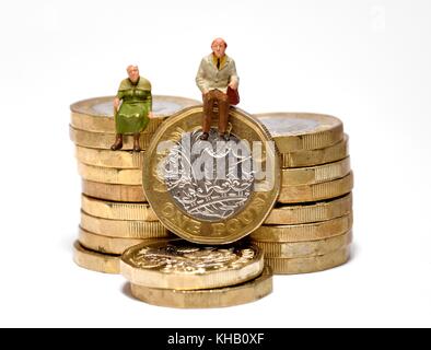Les retraités assis sur British pound coins Banque D'Images