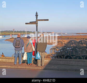 Une vue de trois personnes regardant au-dessus du quai jusqu'au port de Wells-next-the-Sea, Norfolk, Angleterre, Royaume-Uni. Banque D'Images