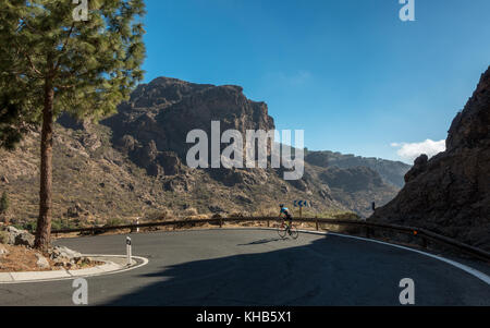 Vélo Cycliste un virage en épingle sur un vélo de route avec vue sur la montagne à l'intérieur des terres en ordre décroissant d'Ayacata sur le GC-600 road, Gran Canaria Banque D'Images
