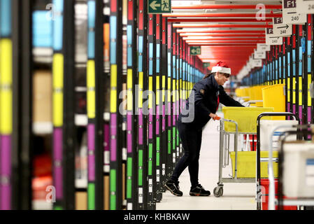 Sous l'embargo du 0001 jeudi 16 novembre le personnel se rend dans les allées pour collecter les articles avant de les envoyer au centre d'expédition sur site pour les emballer dans l'un des plus grands entrepôts Amazon de Dunfermline, Fife, Comme le géant du shopping en ligne se prépare pour la ruée de Noël et les prochaines ventes du Vendredi fou. Banque D'Images