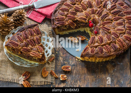 La tarte aux pacanes sur table en bois rustique. Noël cuisson. Banque D'Images