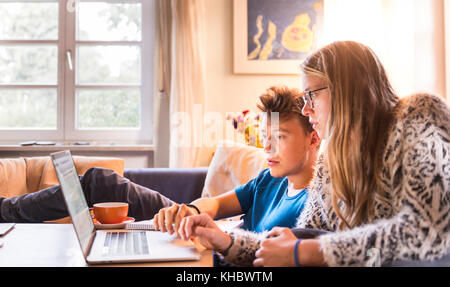 Deux élèves assis devant un ordinateur portable, l'apprentissage sur l'ordinateur, Munich, Allemagne Banque D'Images
