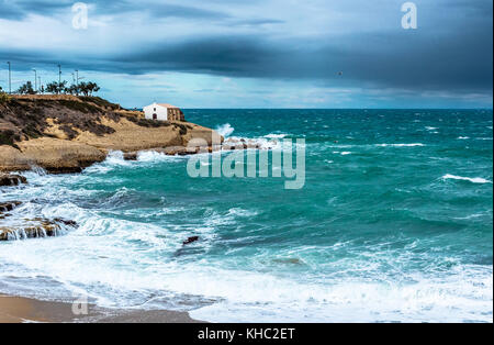 Plage de balai en hiver avec raugh mer avec la petite église sur l'arrière-plan Banque D'Images