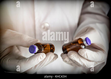 Médecin tient deux flacons dans un hôpital. conceptual image Banque D'Images