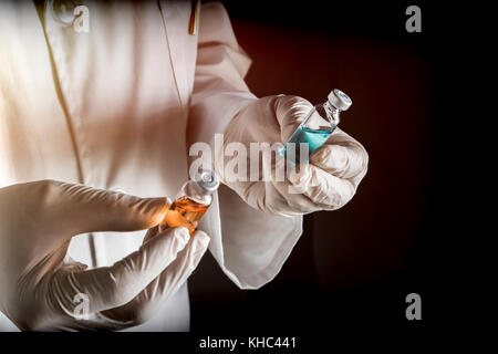 Médecin tient deux flacons dans un hôpital. conceptual image Banque D'Images