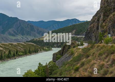 La vue panoramique sur les montagnes, la rivière, la vallée et la route le long de la rivière sur un jour nuageux Banque D'Images