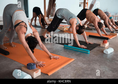 Plusieurs personnes exerçant sur les tapis de yoga Banque D'Images