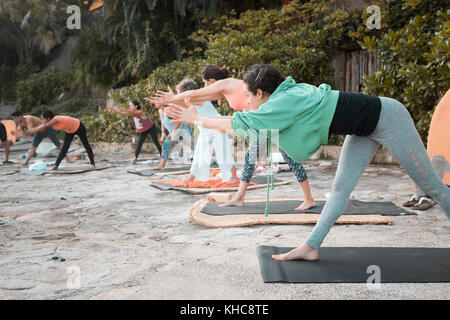 Groupe yoga - plusieurs personnes exerçant à l'extérieur. Banque D'Images