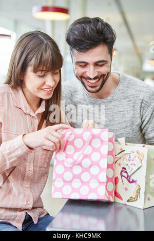 Happy young couple ressemble curieusement dans un sac avec un présent Banque D'Images