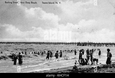 Carte postale de scène de plage photo avec les gens se baigner, long quai hors plage en arrière-plan, intitulé scène de baignade, New Dorp Beach, Staten Island, 1900. De la bibliothèque publique de New York. Banque D'Images