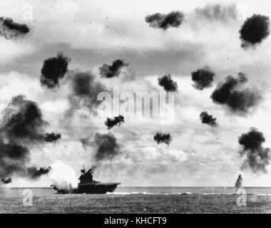 USS Yorktown (CV-5) est frappé sur le côté bâbord, au milieu du navire, par une torpille aérienne Type 91 Japonais en milieu d'après-midi l'attaque par les avions de l'Hiryu transporteur, dans la bataille de Midway, le 4 juin, 1942. Yorktown est au port de gîte et est vue à un aspect différent que dans d'autres vues prises par le USS Pensacola (CA-24), indiquant qu'il s'agit de la deuxième des deux torpedo hits qu'elle a reçu. Remarque très lourd anti-aériens. Banque D'Images