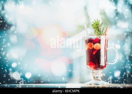 Verre de vin chaud traditionnel ou d'un poinçon sur table au jour d'hiver glacial avec de la neige en arrière-plan Banque D'Images