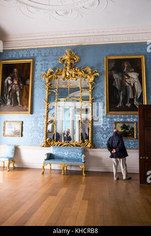 Un homme à la recherche de près les peintures anciennes ornées à l'intérieur de Kedleston Hall, Kedleston, Derbyshire, Angleterre, RU Banque D'Images