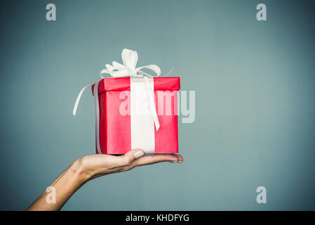 Woman's hand holding wrapped gift Banque D'Images
