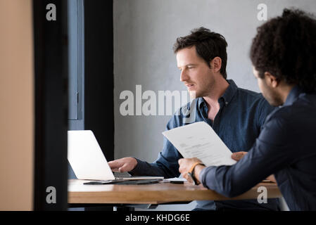 Man alors que d'autres homme lit le document Banque D'Images