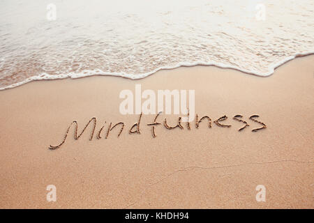 Concept de mindfulness, conscient vivant, du texte écrit sur le sable de plage Banque D'Images