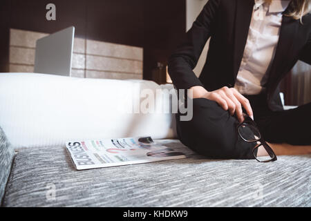 Businesswoman reading magazine dans l'hôtel Banque D'Images