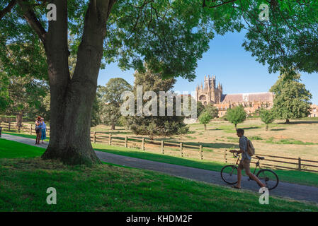 Vue sur la ville d'Ely, un jeune cycliste pousse son vélo le long d'un chemin dans le parc de Cherry Hill à la périphérie de la ville d'Ely à Cambridgeshire, en Angleterre. Banque D'Images