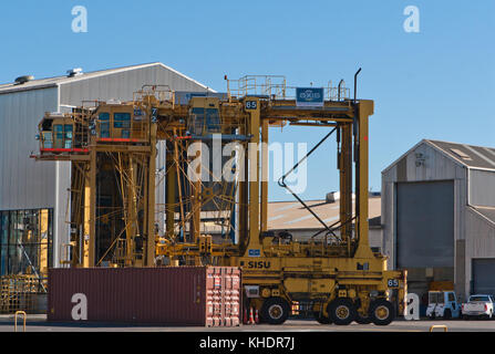 Auckland, Nouvelle-Zélande - 2 avril 2012 : quatre noell chariots et pile de conteneurs dans le port de mer d'Auckland. Banque D'Images