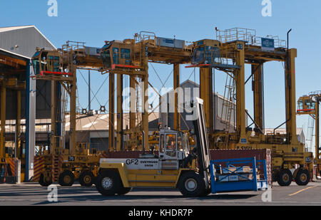 Auckland, Nouvelle-Zélande - 2 avril 2012 : quatre noell chariots et pile de conteneurs dans le port de mer d'Auckland. Banque D'Images