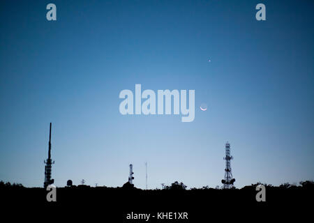 Antennes de station de relais de diffusion en montée.Lune et les planètes Vénus et Mars forment une conjonction dans le ciel juste avant de monter Banque D'Images