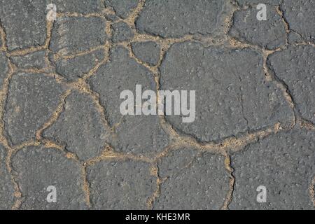 Surface d'asphalte fissurée gris arrière-plan. Banque D'Images