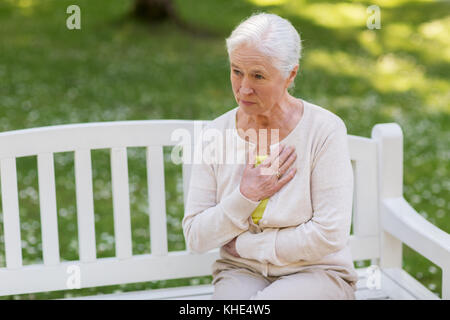 Woman sensation de malaise au parc d'été Banque D'Images