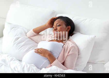 Pregnant woman lying in bed at home Banque D'Images