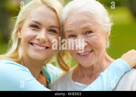 Fille avec de hauts mother hugging on park bench Banque D'Images