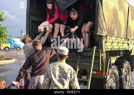 Les soldats aident les résidents secourus à l'arrière d'un véhicule de haute mer après de graves inondations à Baton Rouge, EN LOUISIANE, le 14 août 2016. Les gardes ont secouru plus de 3,400 personnes et 400 animaux depuis le début des opérations le 12 août 2016. Photo de la Garde nationale de l'armée par le 1er lieutenant Gomez Banque D'Images