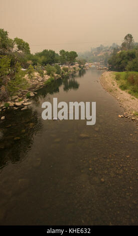 Un garçon joue dans un ruisseau, près d'un des nombreux lieux de loisirs du lac Isabella, près de Kernville, CA, le samedi 20 août 2016. La fumée du feu de cèdre dans la forêt nationale de Sequoia traverse la région et teinte la lumière du soleil en fin d'après-midi. Photo USDA par lance Cheung. Banque D'Images