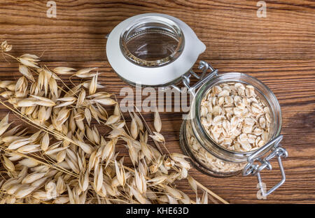 Flocons d'avoine naturelle et de mûre sur une table. détail des grains et flocons d'avoine en pot sur fond de bois. Banque D'Images