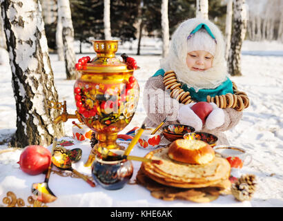 Petite fille en robe et foulard dans la Fédération de samovar dans la ba Banque D'Images