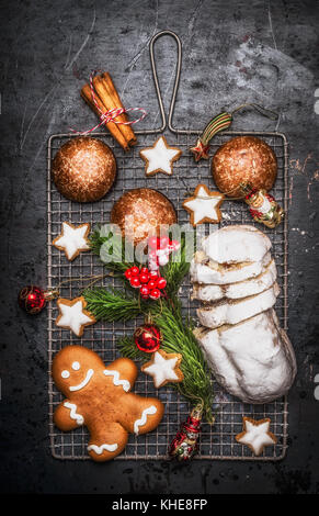 Doux Noël Nourriture cuisson : des épices, biscuits, stollen aux épices , branches de sapin et décorations de Noël rouge foncé sur fond rustique, Banque D'Images